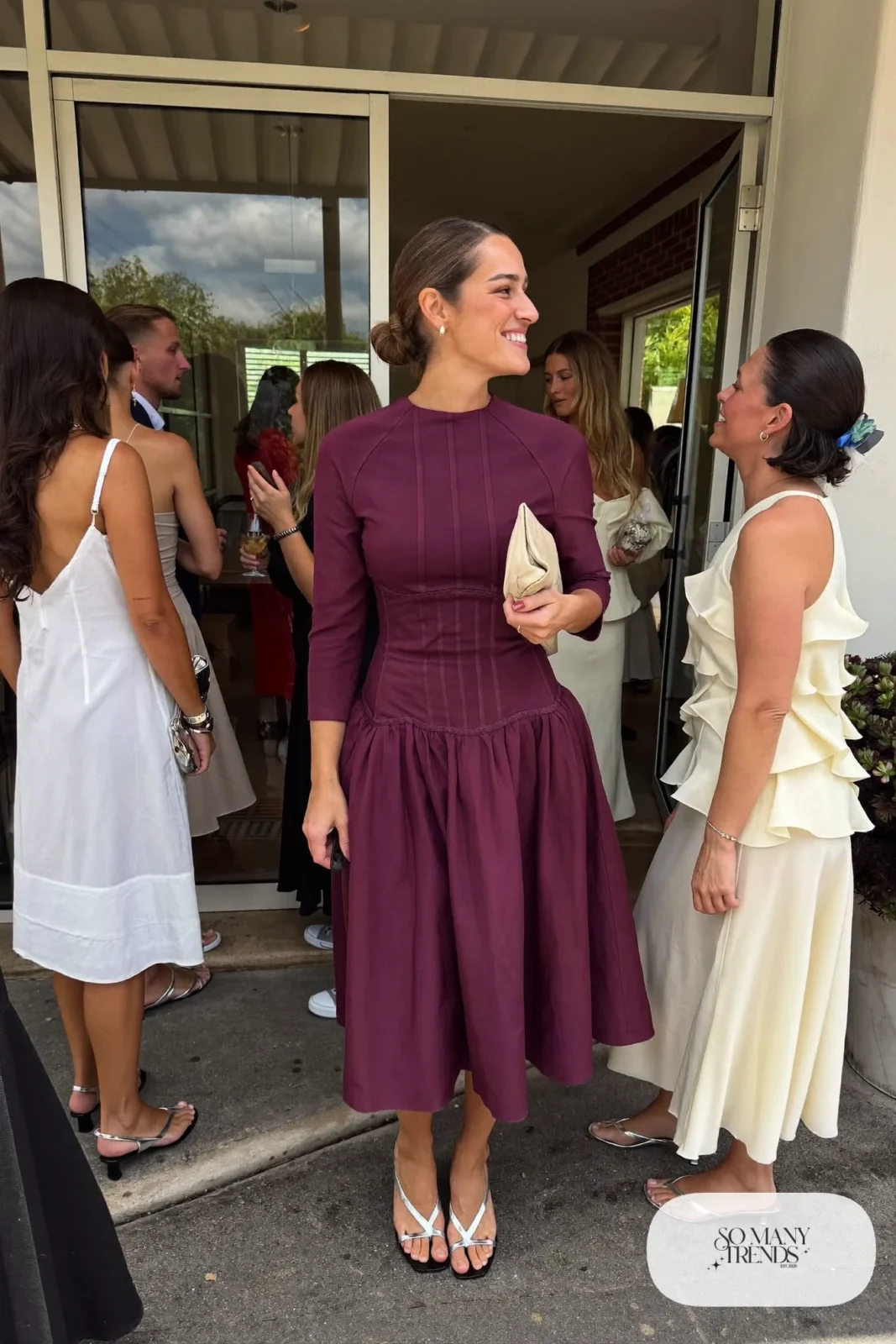Woman in an eggplant crepe corset midi dress with long sleeves and metallic sandals, outfit 18