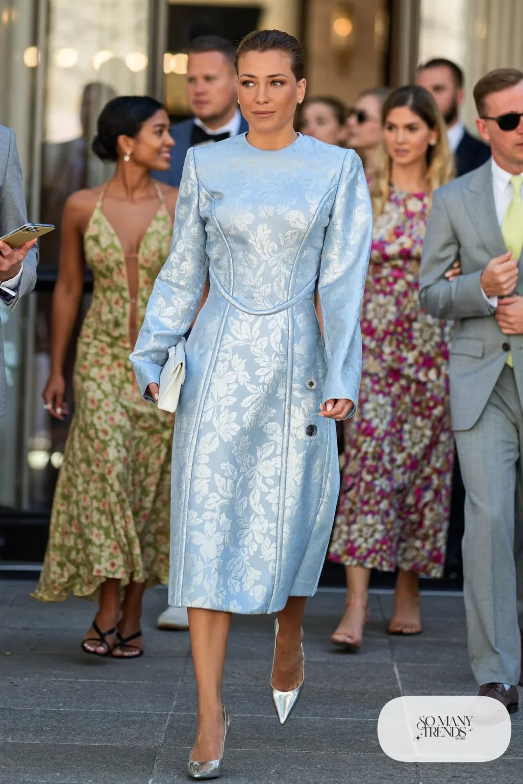 Woman in an icy blue and silver floral jacquard corset midi dress with long sleeves, outfit 25