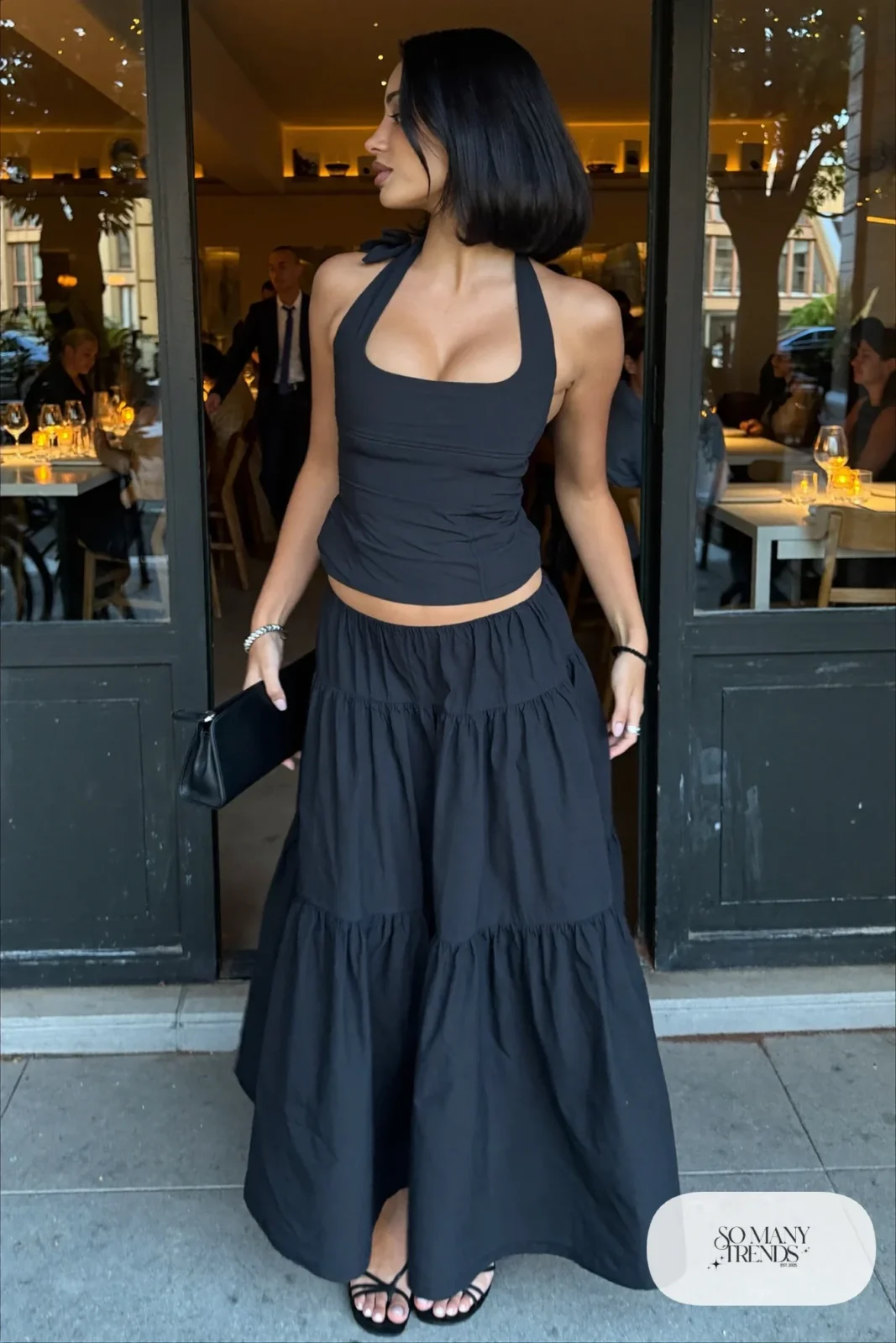 Black tiered maxi skirt with fitted black halter top and strappy black heeled sandals, outfit 7