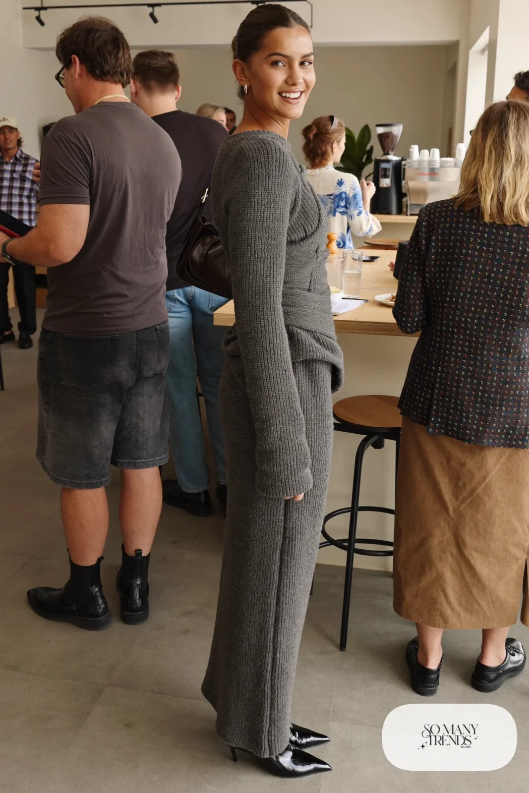 Woman in a charcoal ribbed knit corset maxi dress with long sleeves and sleek boots, outfit 19