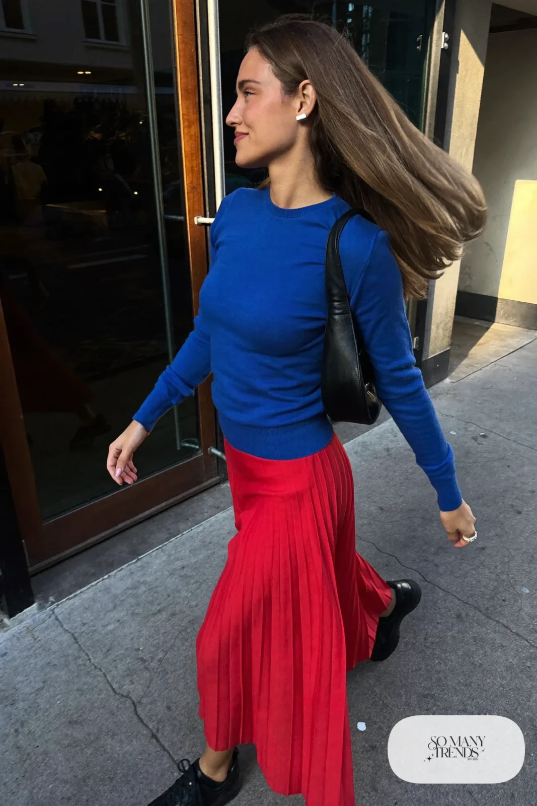 Fitted cobalt blue knit sweater, long red pleated midi skirt and black ankle-height sneakers, outfit 3