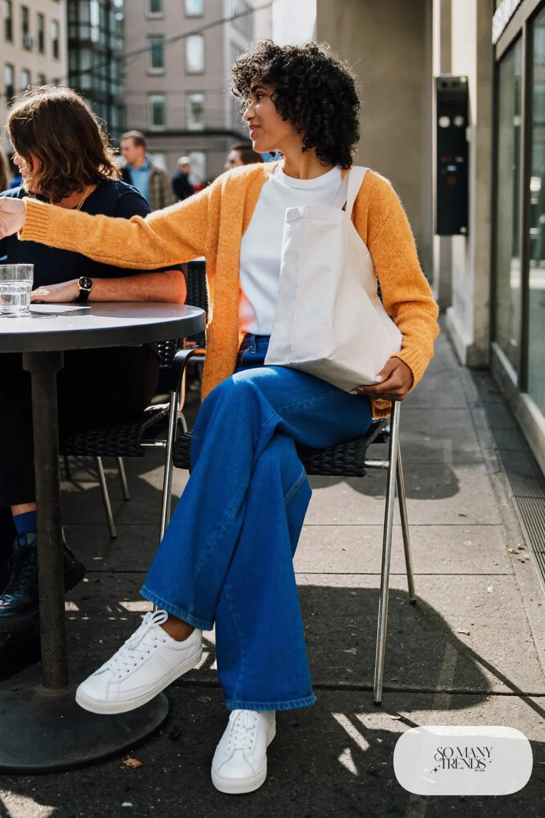 Mustard yellow knit cardigan over a white tee with cobalt straight-leg jeans and white sneakers, outfit 4