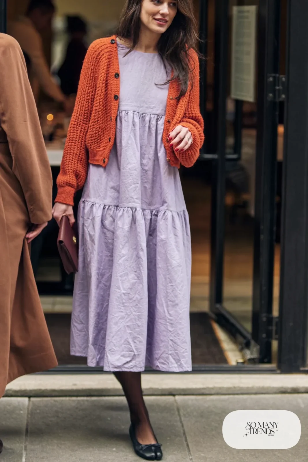 Short burnt orange knit cardigan over a loose lilac midi dress with sheer tights and black flats, outfit 28