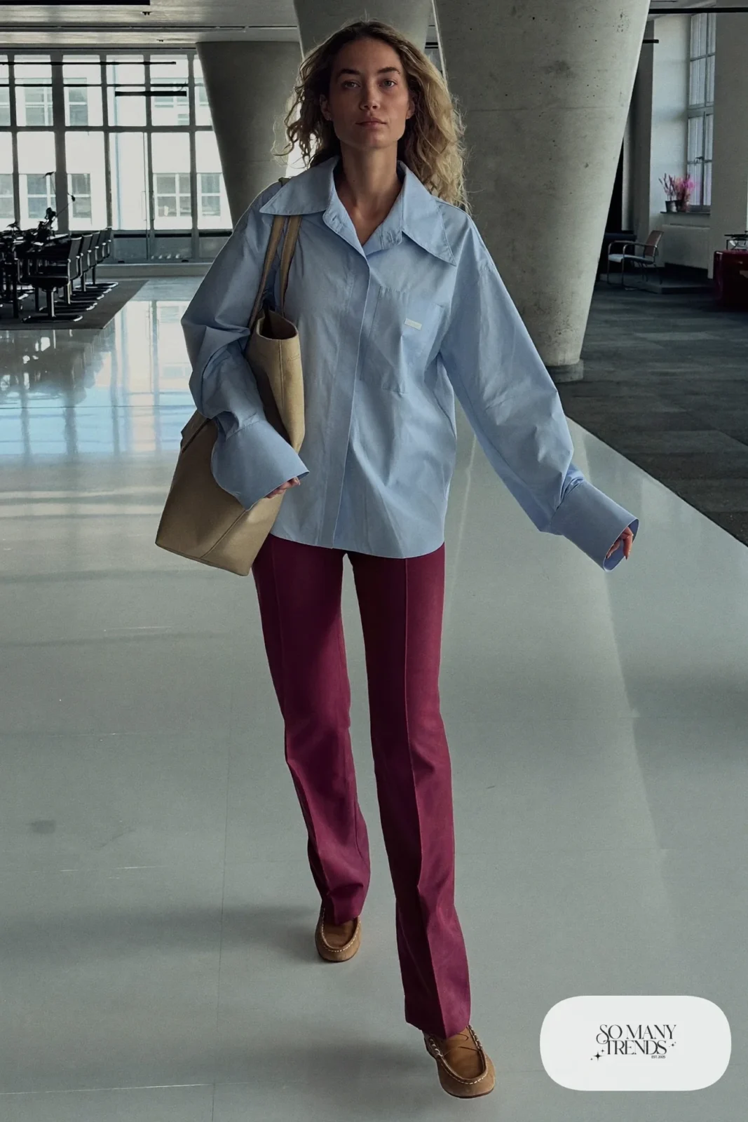 Woman in plum straight pants, powder blue shirt and tan loafers walking in an office lobby, outfit 14