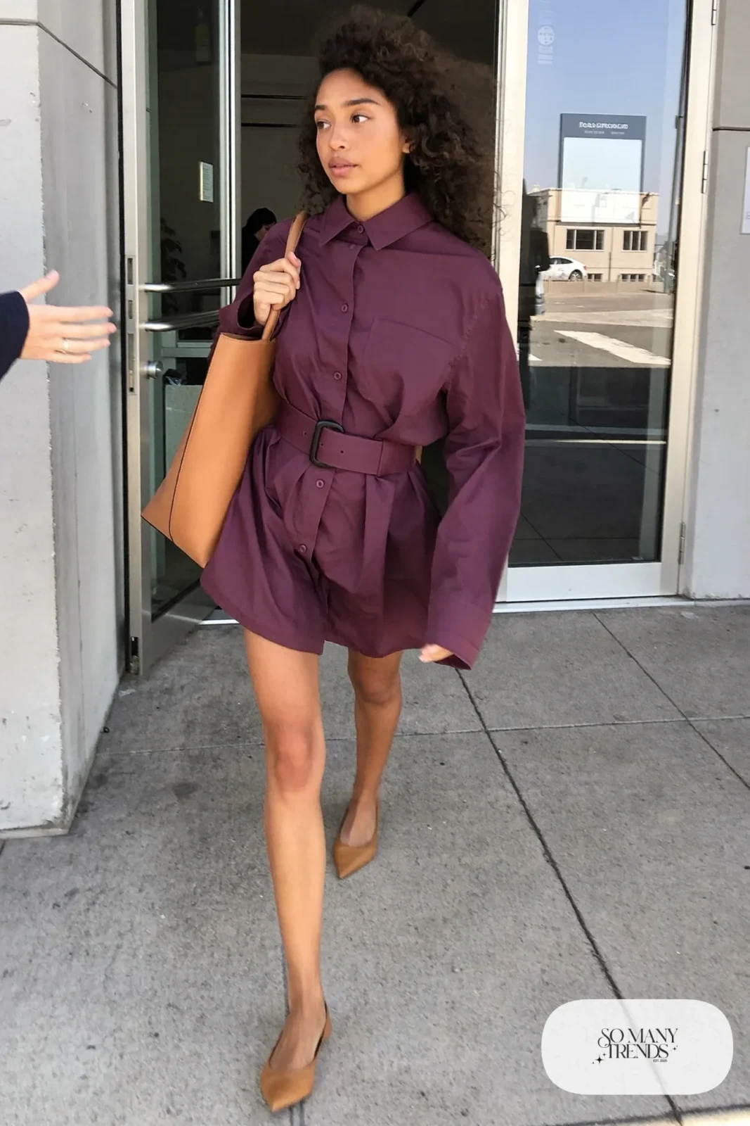 Woman in a belted plum shirt dress and tan pointed flats at a downtown office, outfit 17