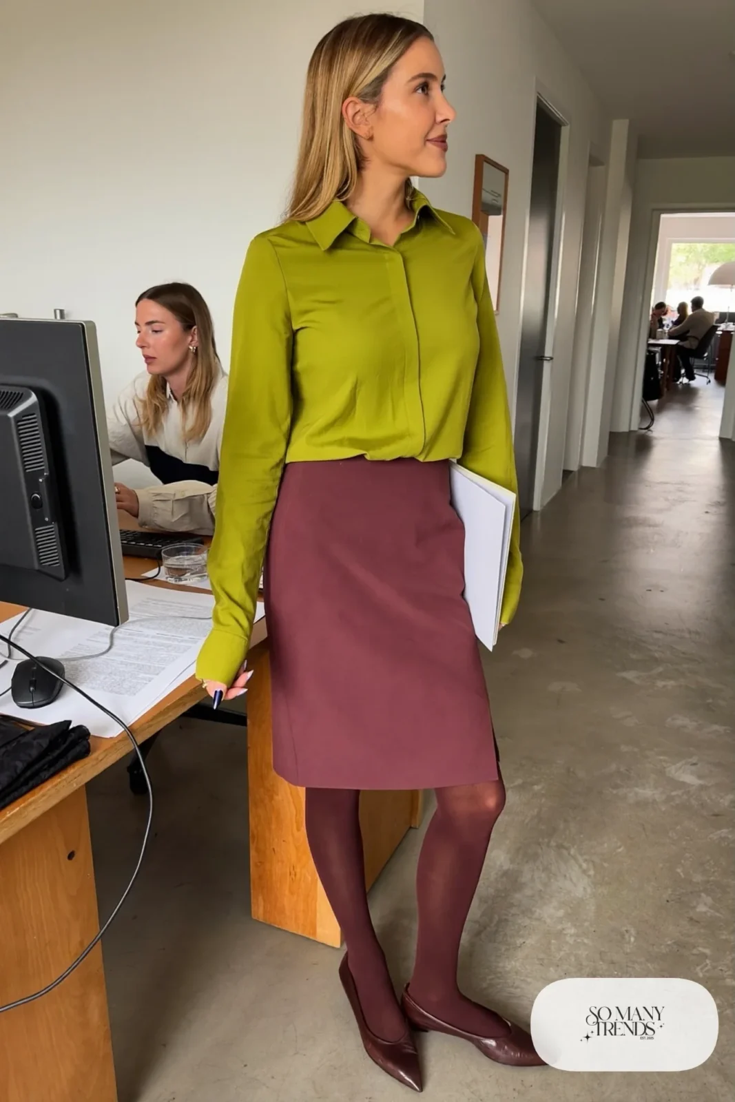 Woman in a plum pencil skirt, chartreuse blouse, sheer tights and brown flats at an office desk area, outfit 21
