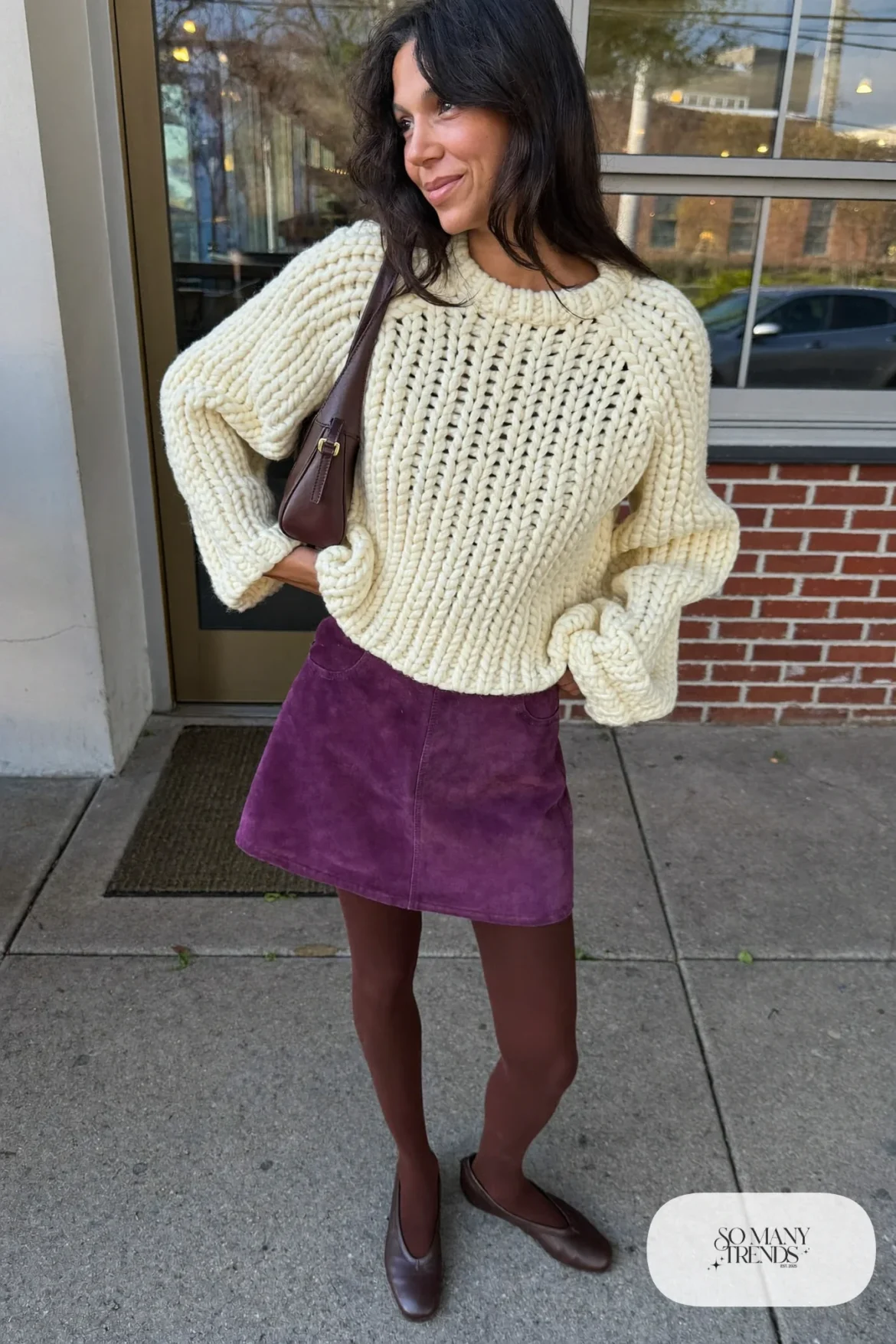 Woman in a plum suede mini skirt, chunky cream sweater, brown tights and flats at a casual dinner, outfit 25