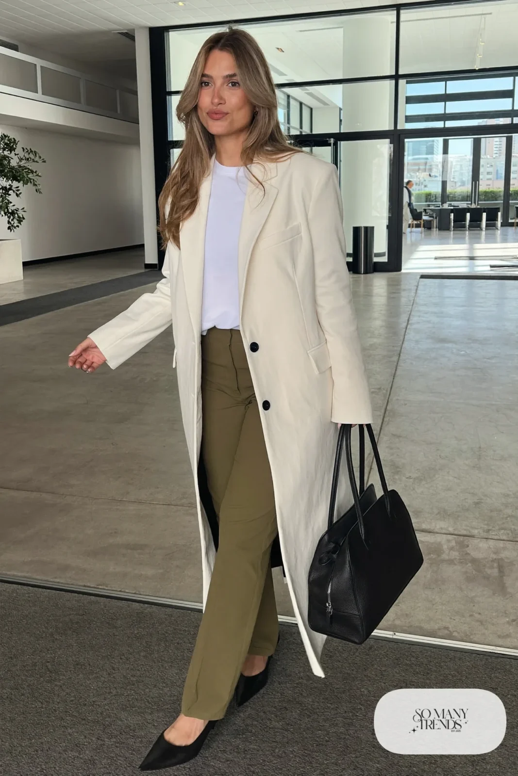 Woman in an ivory blazer, white tee, straight olive pants and black pointed flats, outfit 2