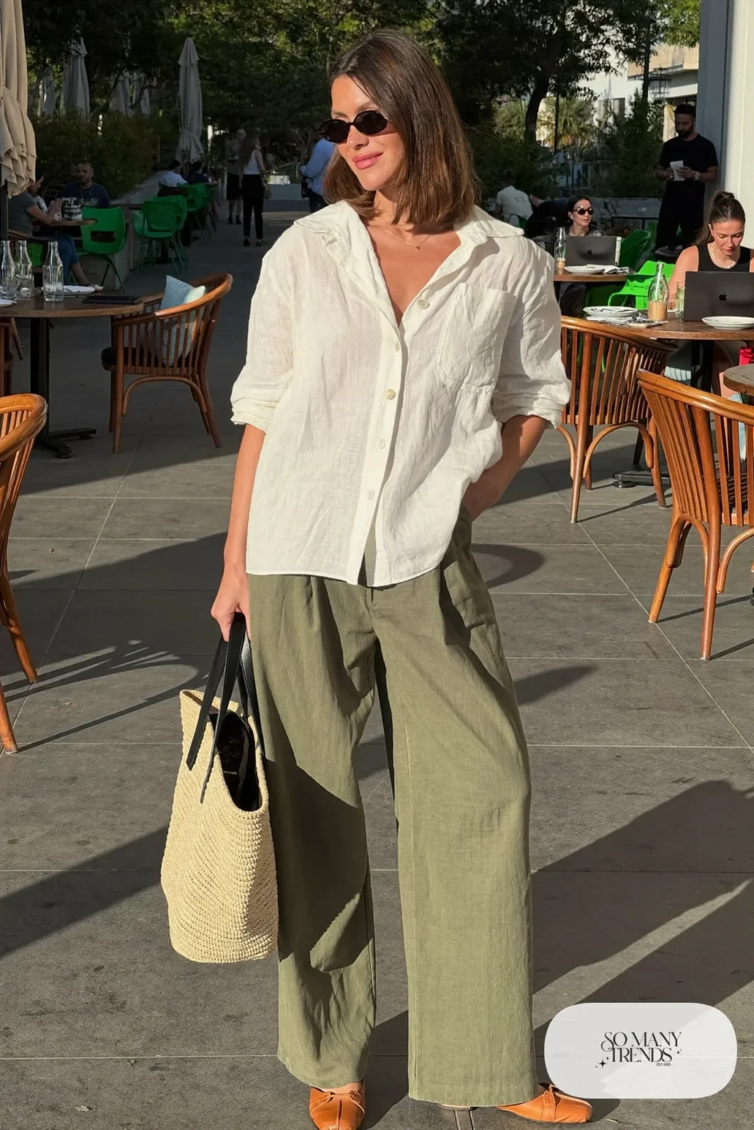 Woman in a cream linen shirt with rolled sleeves, pleated olive pants and brown sandals-free tan flats, outfit 5