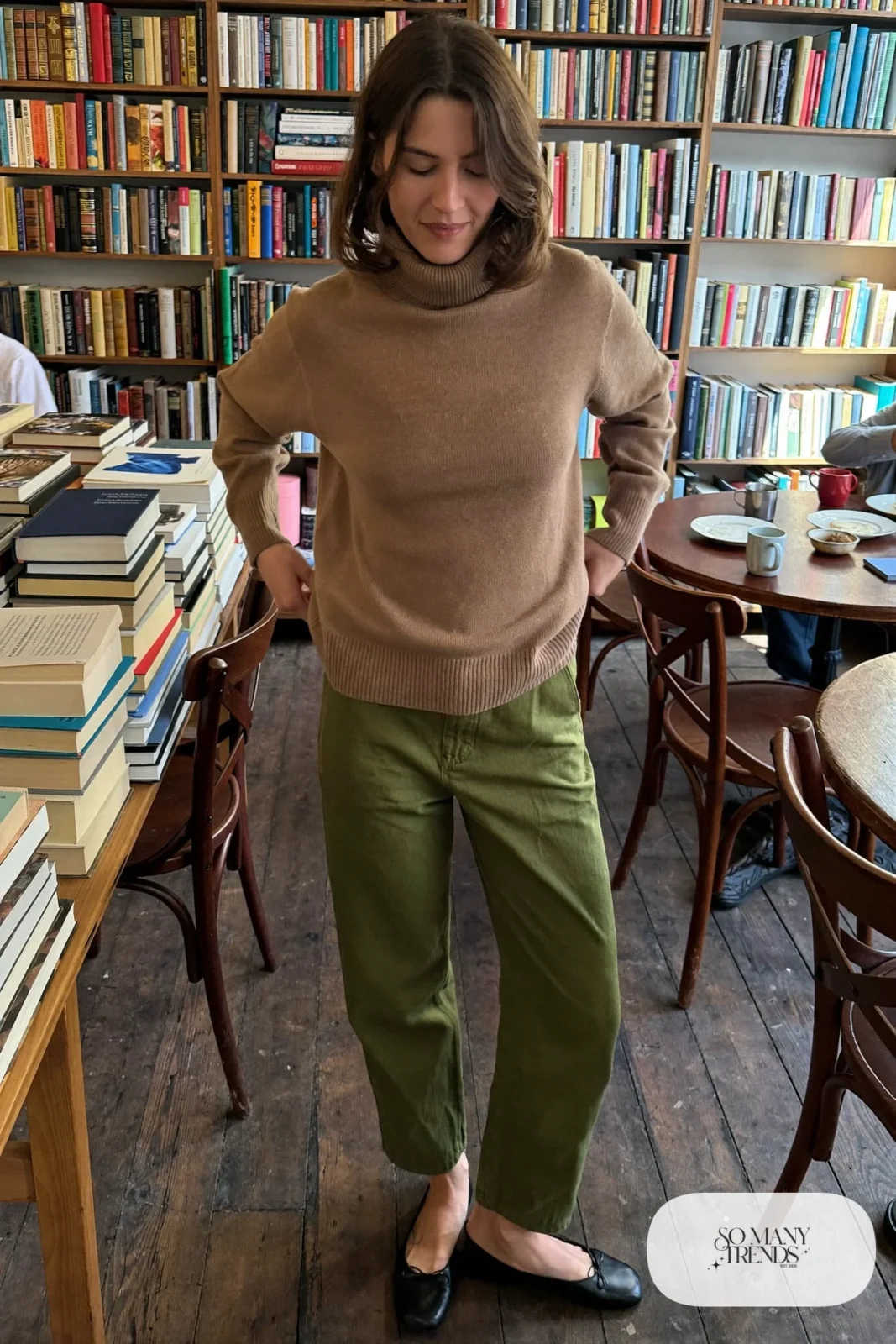 Woman in a camel fine-knit turtleneck, straight olive pants and black ankle-free flats, outfit 7