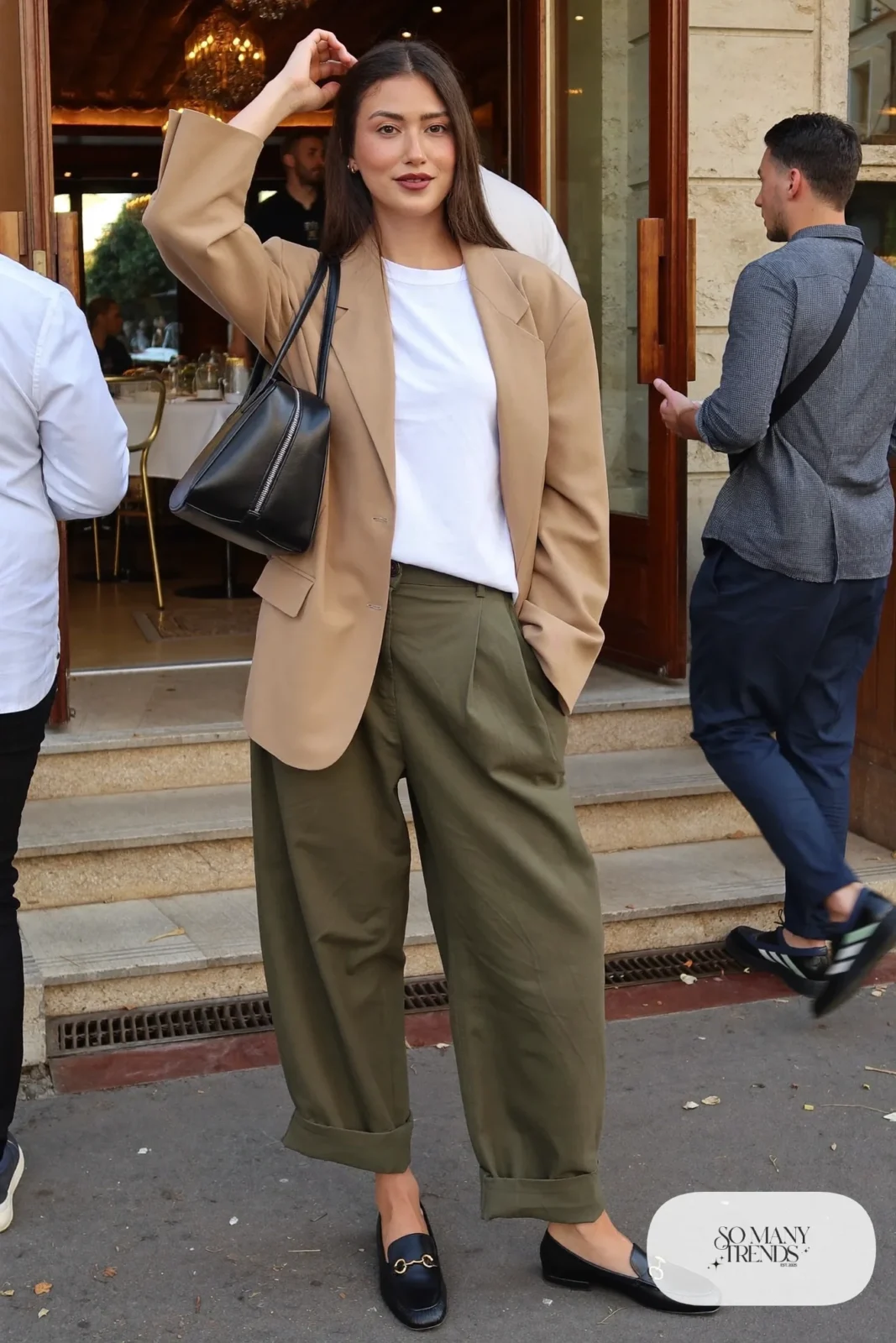 Woman in a camel boxy blazer, white tee, olive wide-leg pants and black loafers, outfit 8