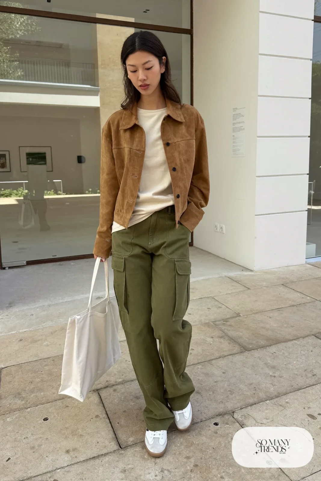 Woman in a short tan suede jacket, cream tee, olive pants and white sneakers, outfit 9