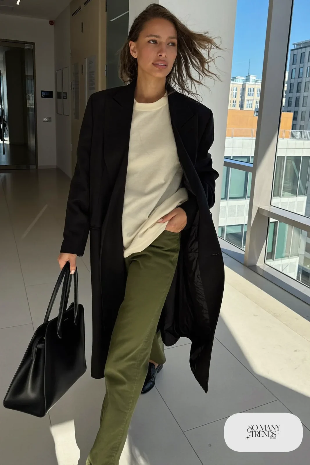 Woman in a black long blazer, cream tee, olive pants and black loafers, outfit 20