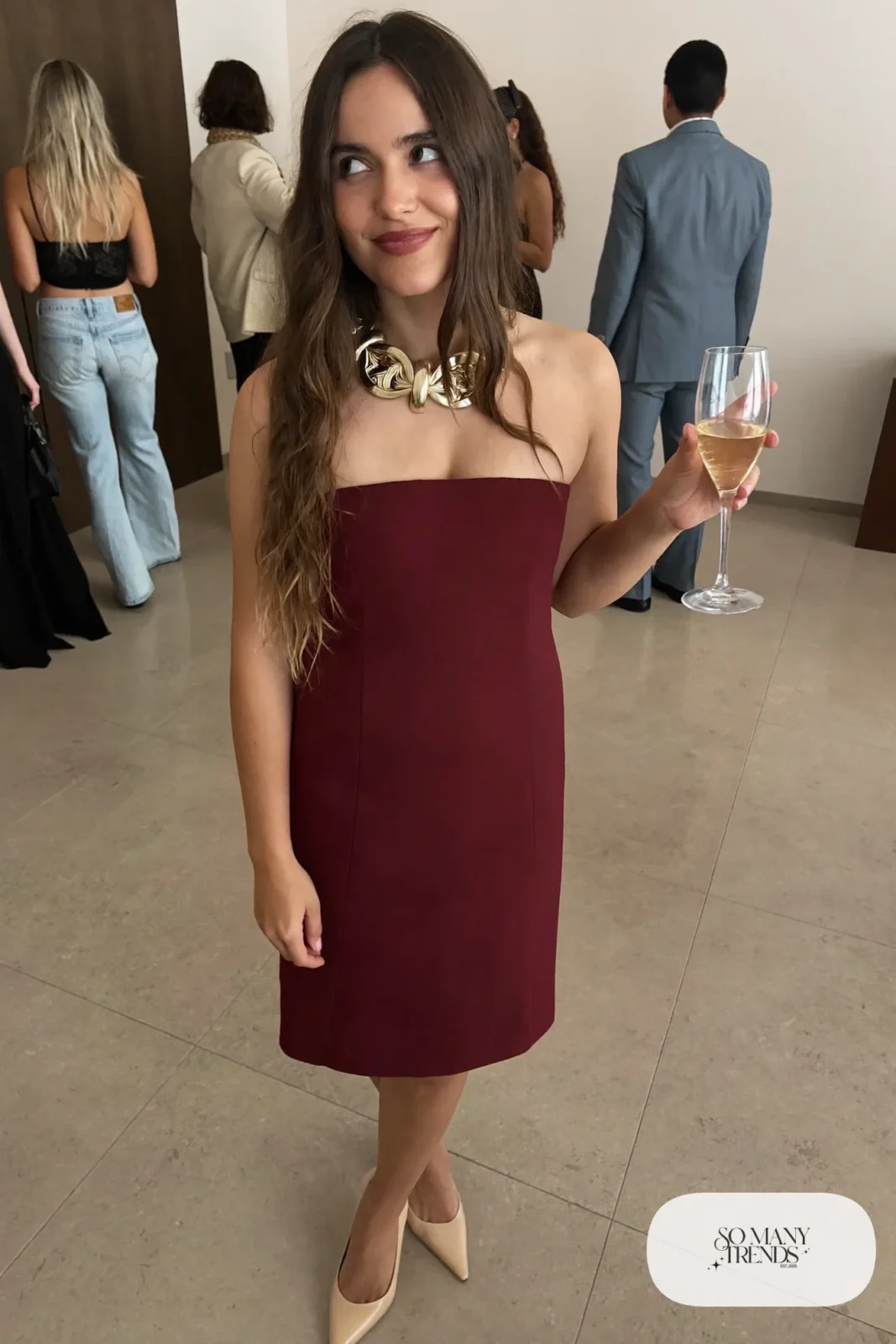 Woman in a wine strapless knee-length dress with a rigid statement collar necklace, bare legs and nude heels, outfit 24
