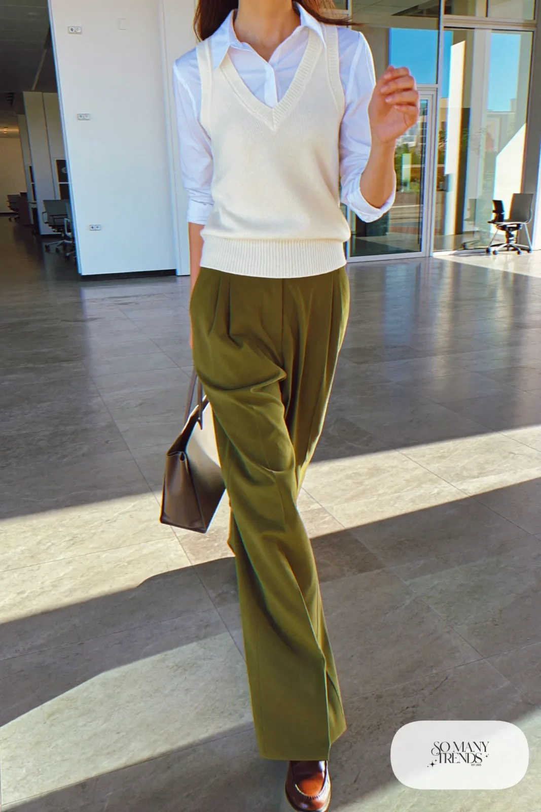 Woman in an ivory knit vest over a white shirt with olive trousers and brown loafers, outfit 6