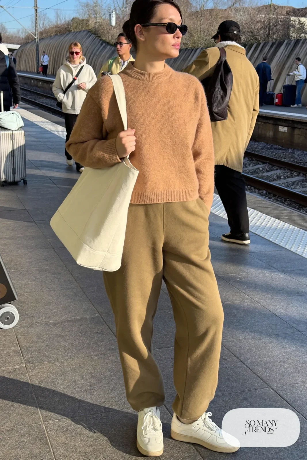 Woman in a camel boxy sweater, tapered olive joggers and cream sneakers, outfit 26