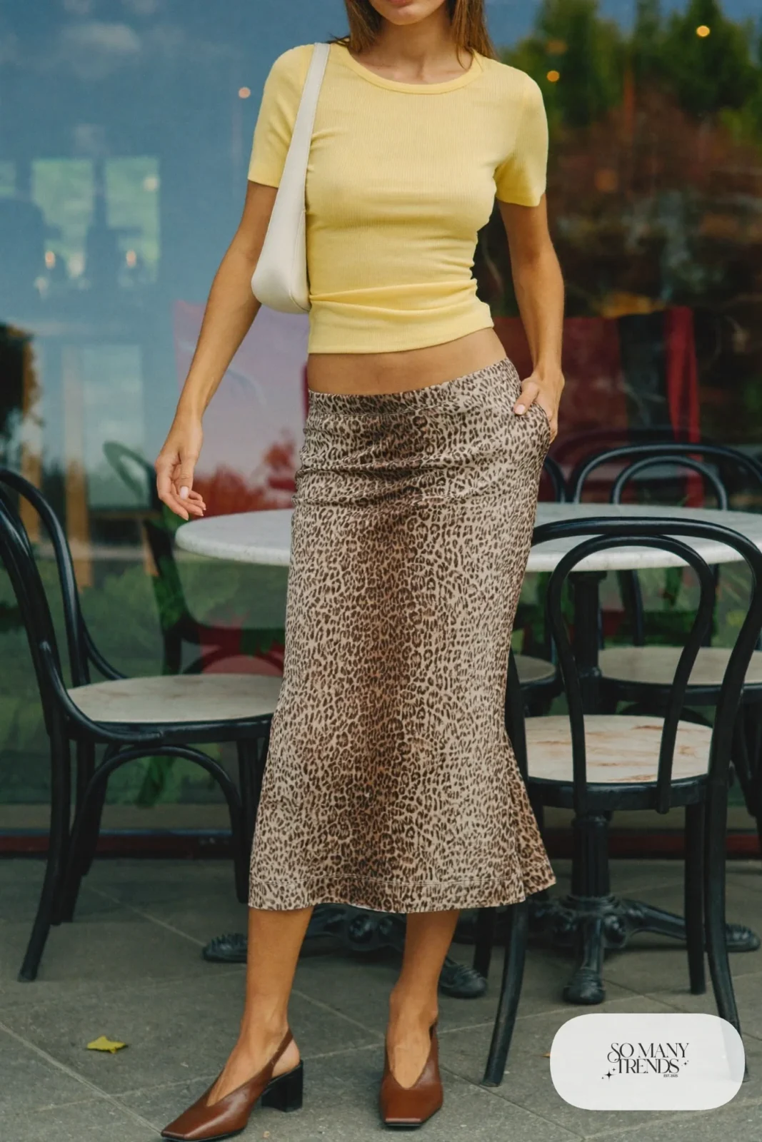 Woman in a butter yellow fitted knit top, tan and black leopard print midi skirt and chocolate brown slingback heels, outfit 1