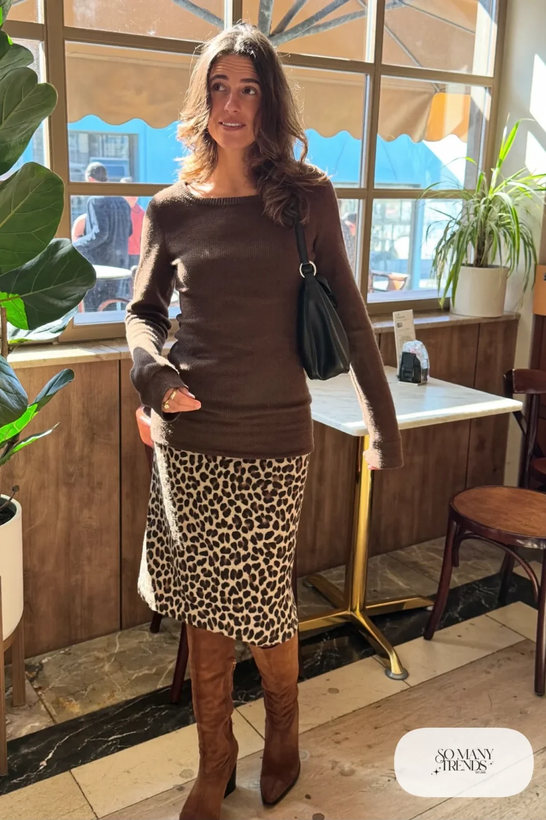 Woman in a chocolate brown slim knit top, cheetah print midi skirt and brown suede knee-high boots, outfit 3