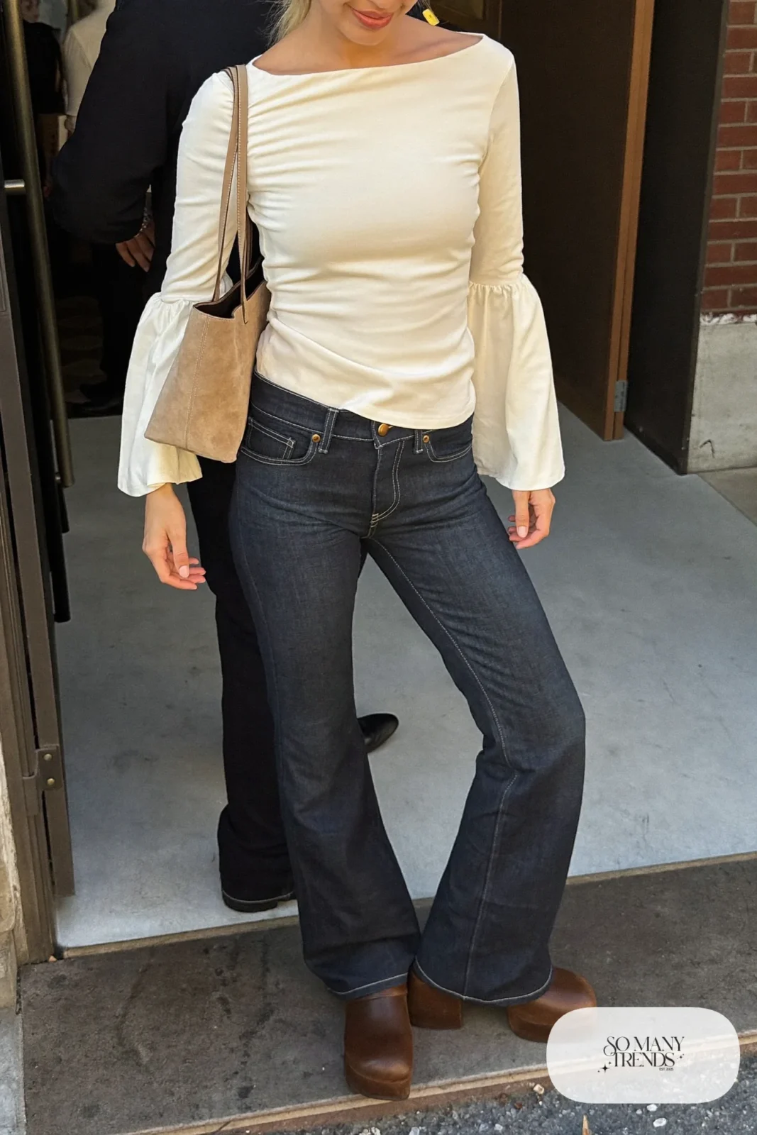 Look 17: cream bell sleeve top, dark wash high-rise flare jeans and brown platform clogs