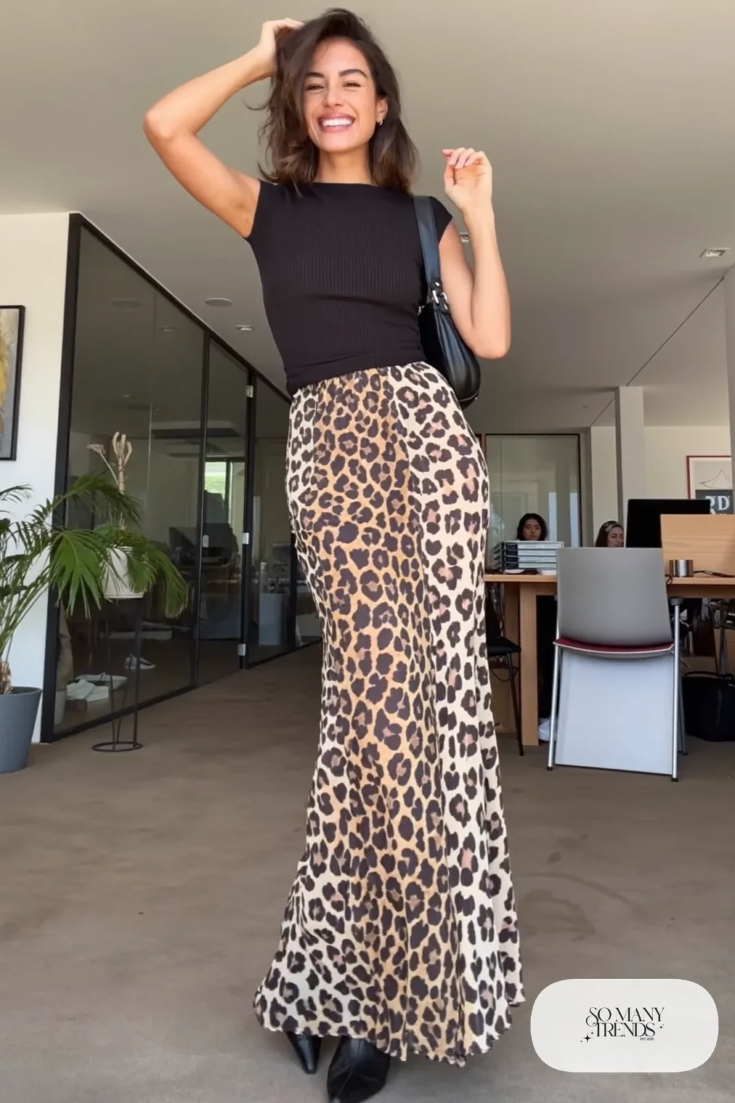 Woman in a black fitted ribbed top, leopard print maxi skirt and black pointed ankle-length boots, outfit 8