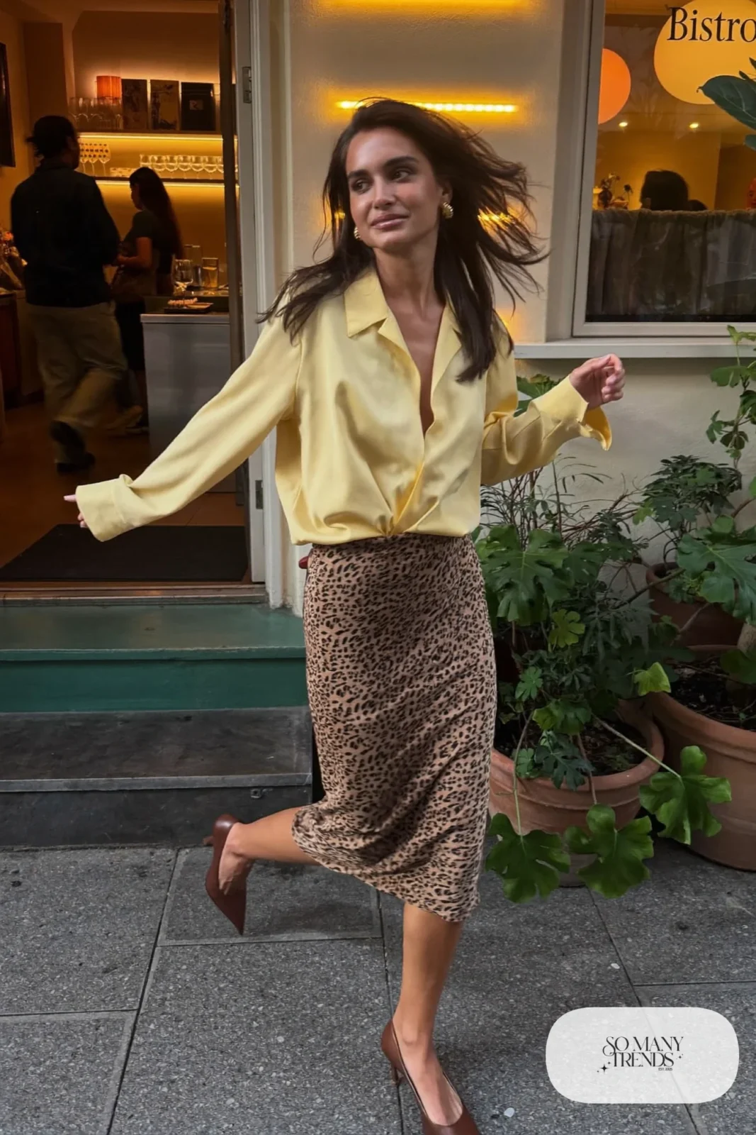 Woman in a butter yellow draped blouse, leopard print slim midi skirt and chocolate brown pointed pumps, outfit 15