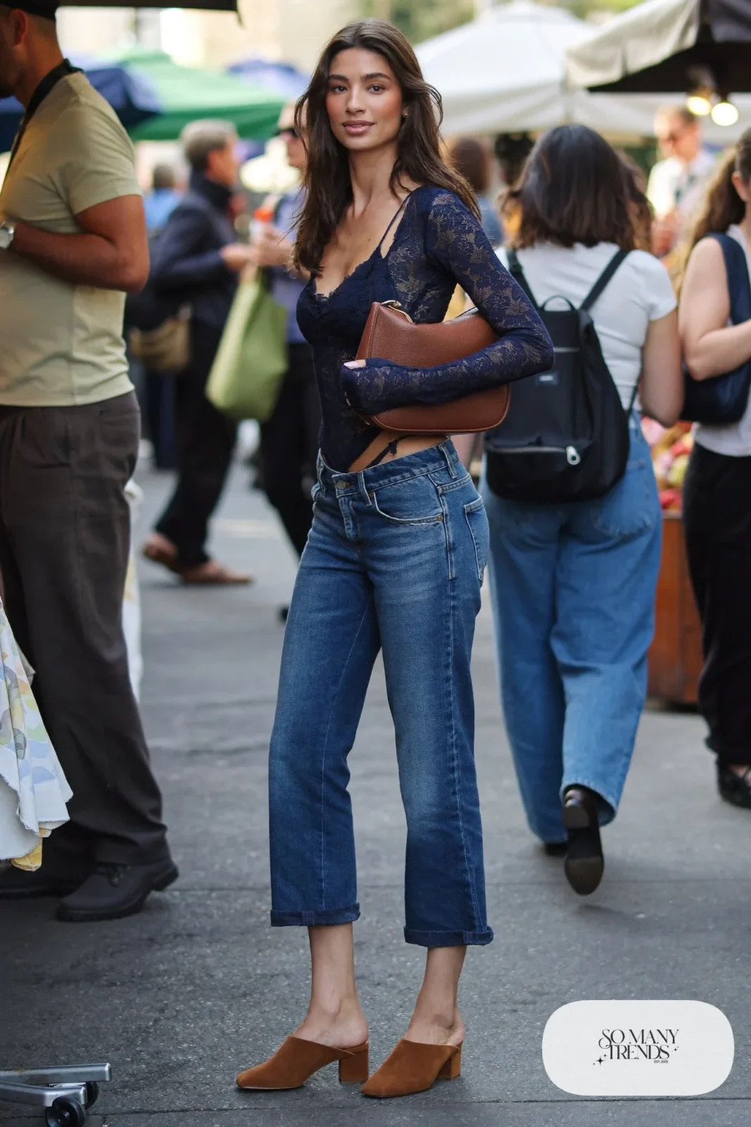 Navy long-sleeve lace top with mid blue barrel-leg jeans, tan suede mules and a small shoulder bag, look 4