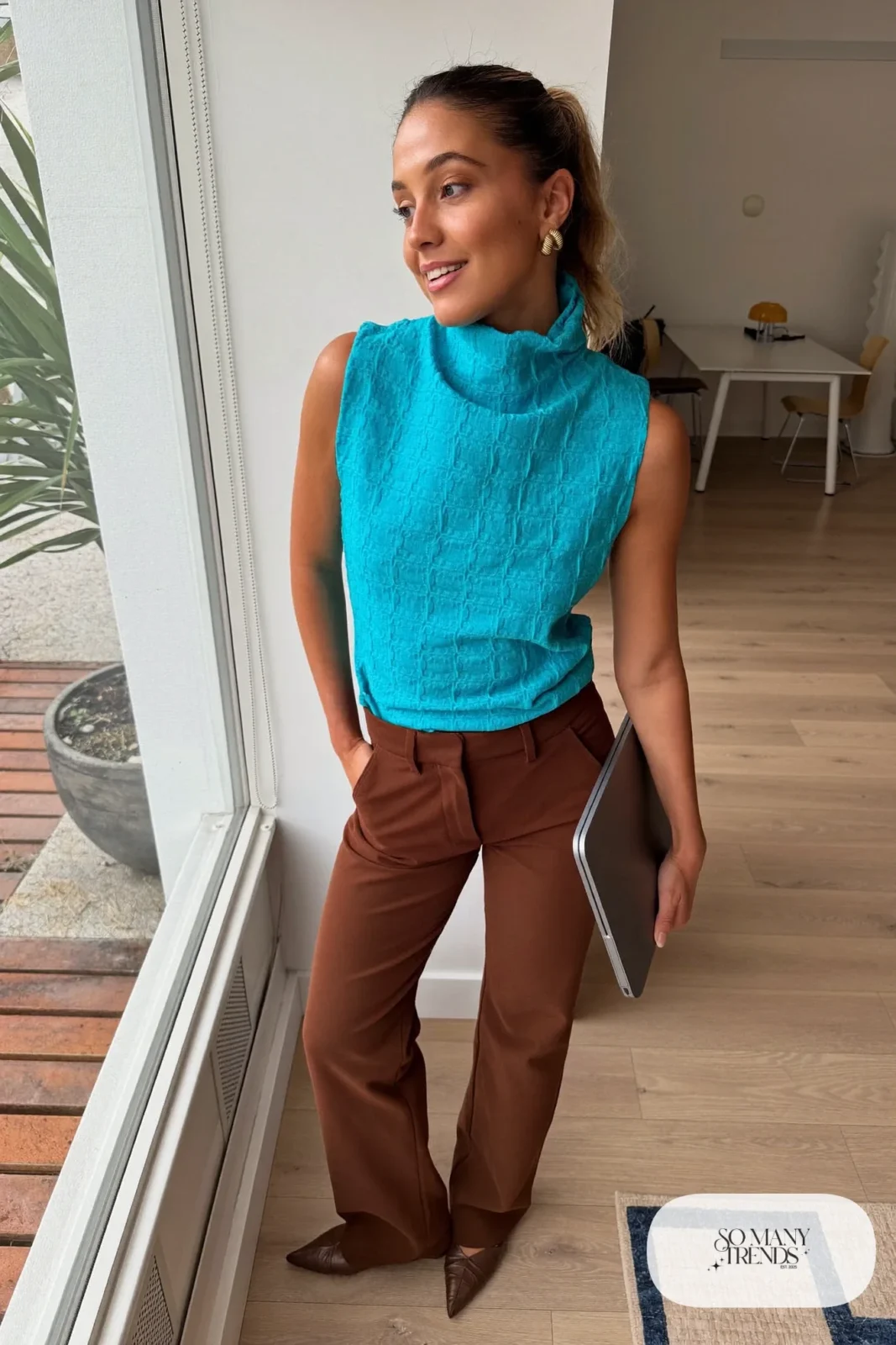 Woman in a turquoise sleeveless shell, chocolate brown straight pants and brown pointed flats, outfit 5