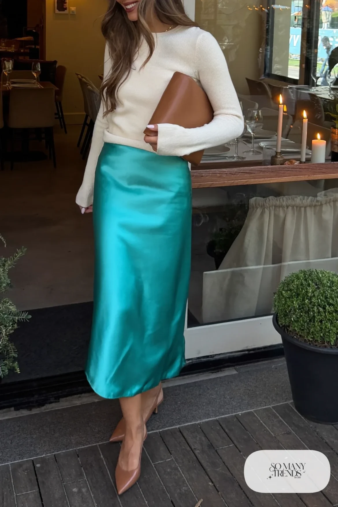 Woman in a turquoise satin midi skirt, cream ribbed sweater and tan slingback pumps, outfit 7