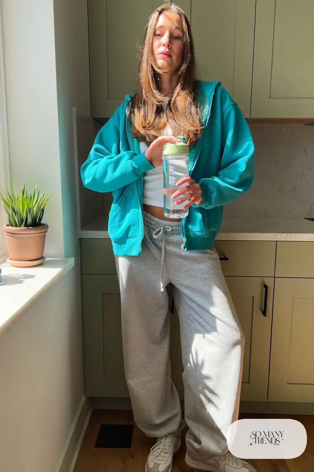 Woman in a turquoise zip hoodie, white tee, gray sweatpants and white sneakers, outfit 20