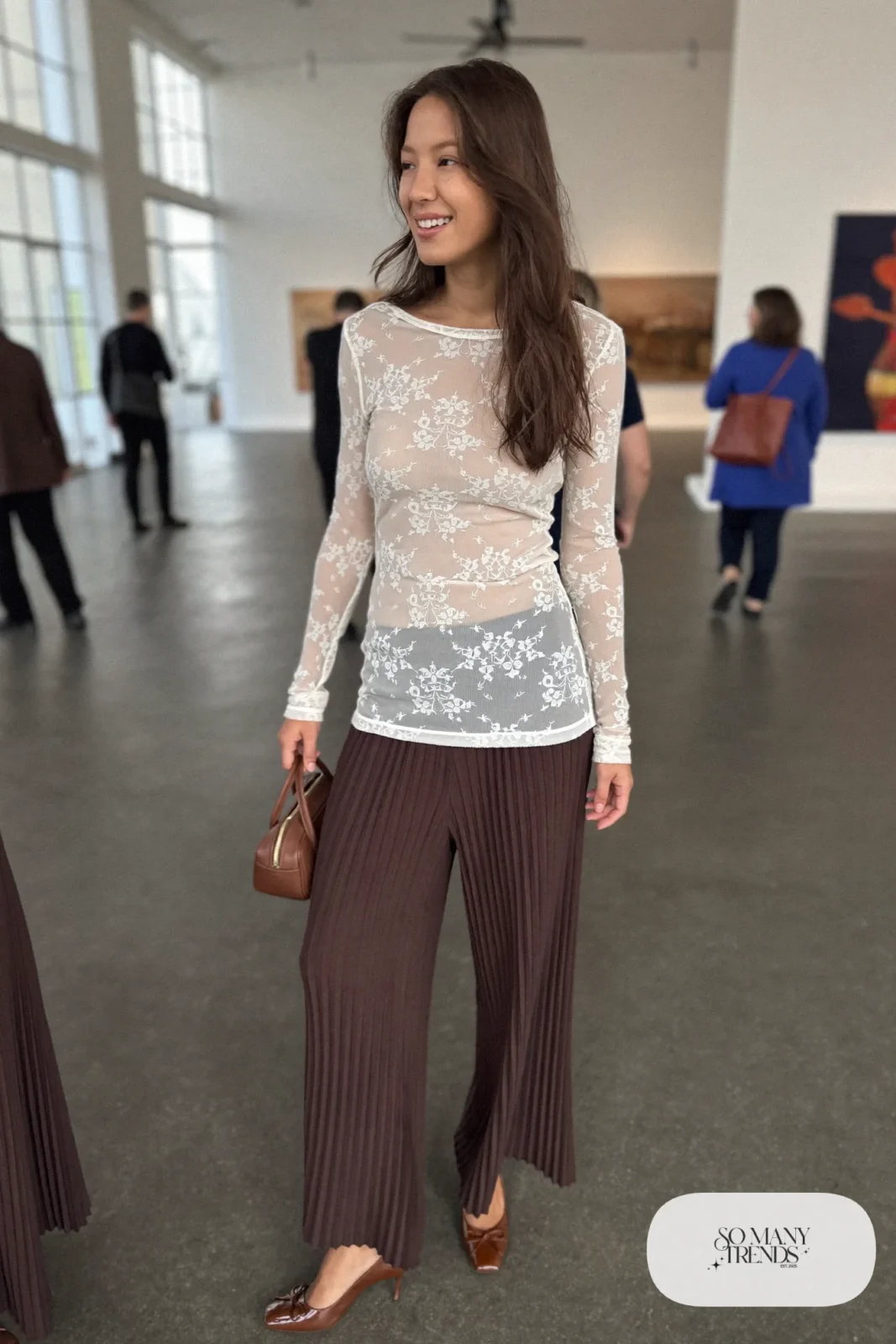Ivory long-sleeve lace top tucked into chocolate brown pleated wide-leg pants with a brown belt and brown pumps, look 7