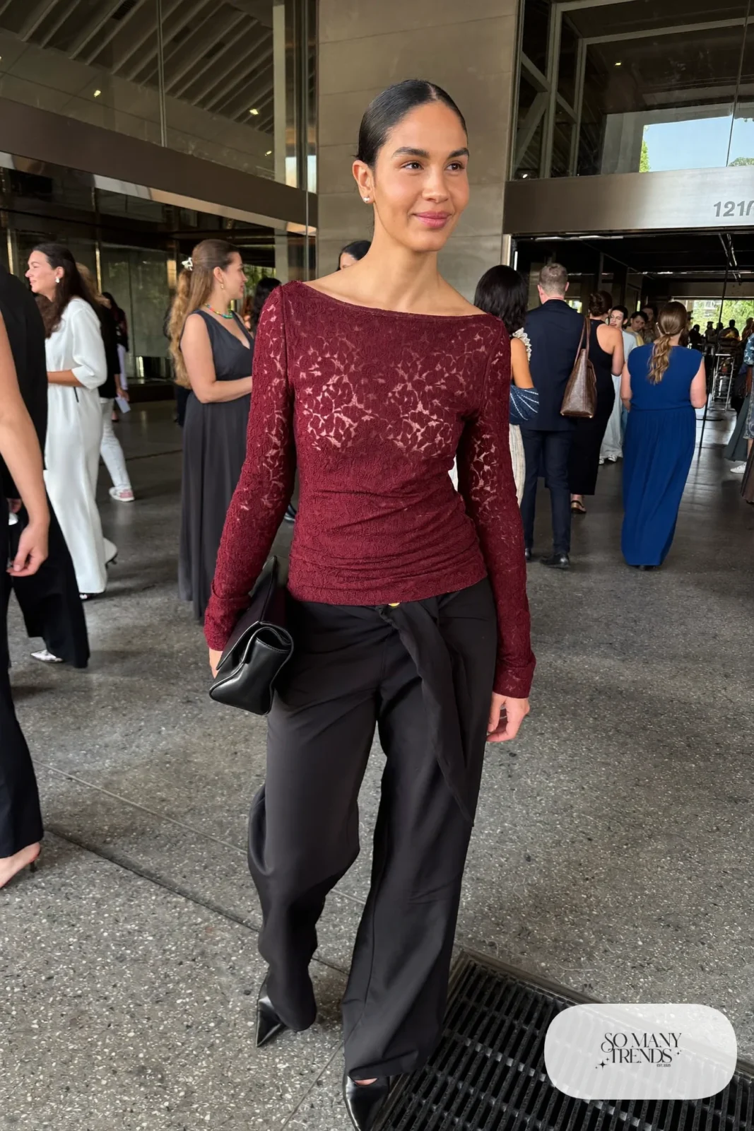 Burgundy long-sleeve lace top with wide black pants, black pumps and a small black bag, look 26