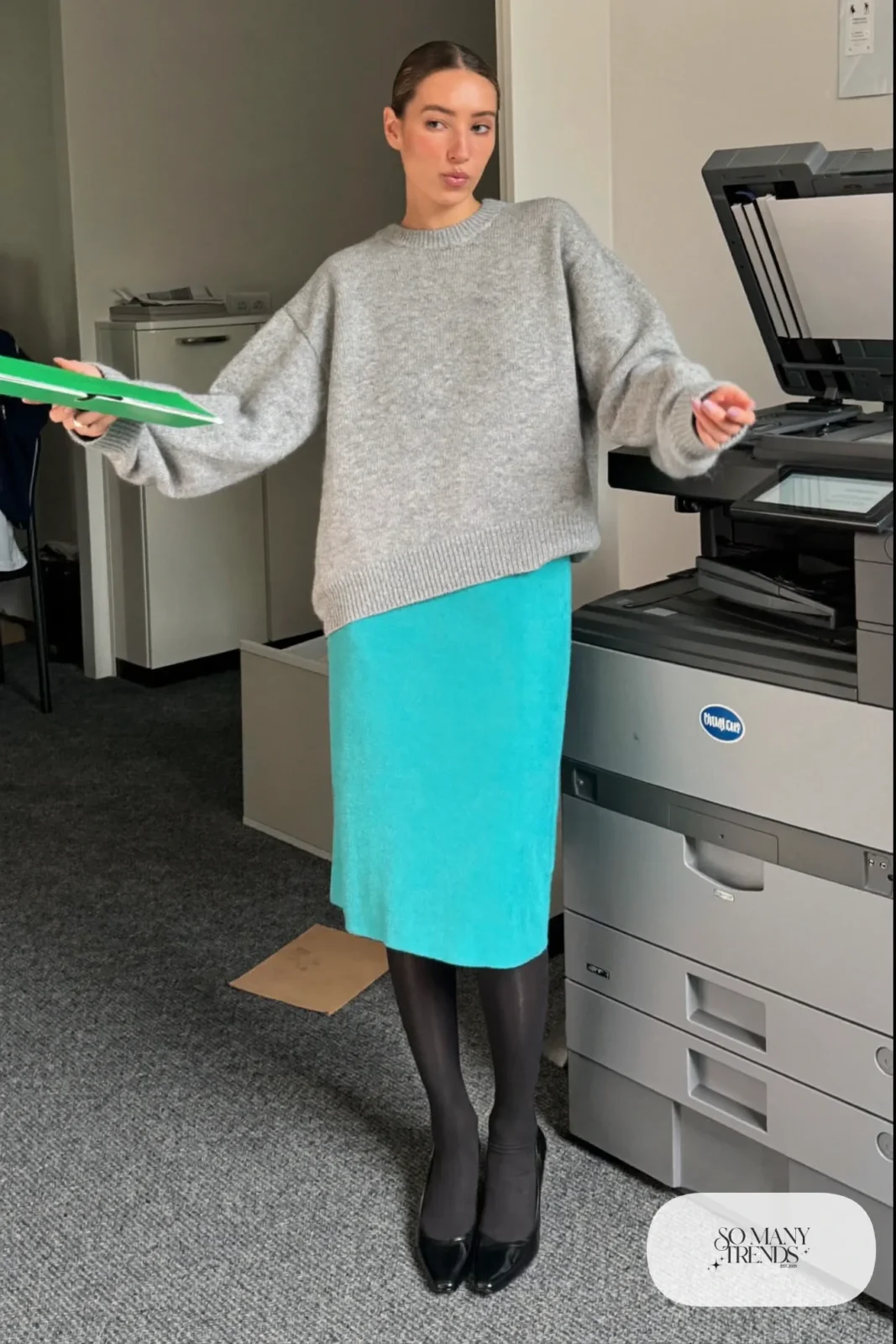 Woman in a turquoise pencil skirt, loose gray sweater, gray tights and black pumps, outfit 9