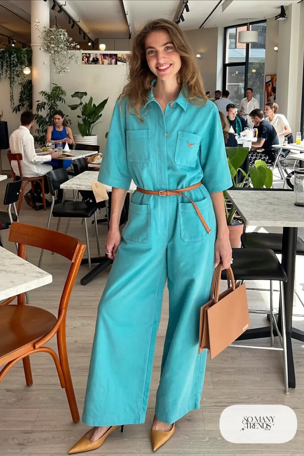 Woman in a turquoise wide-leg jumpsuit with a camel belt and tan pointed flats, outfit 10