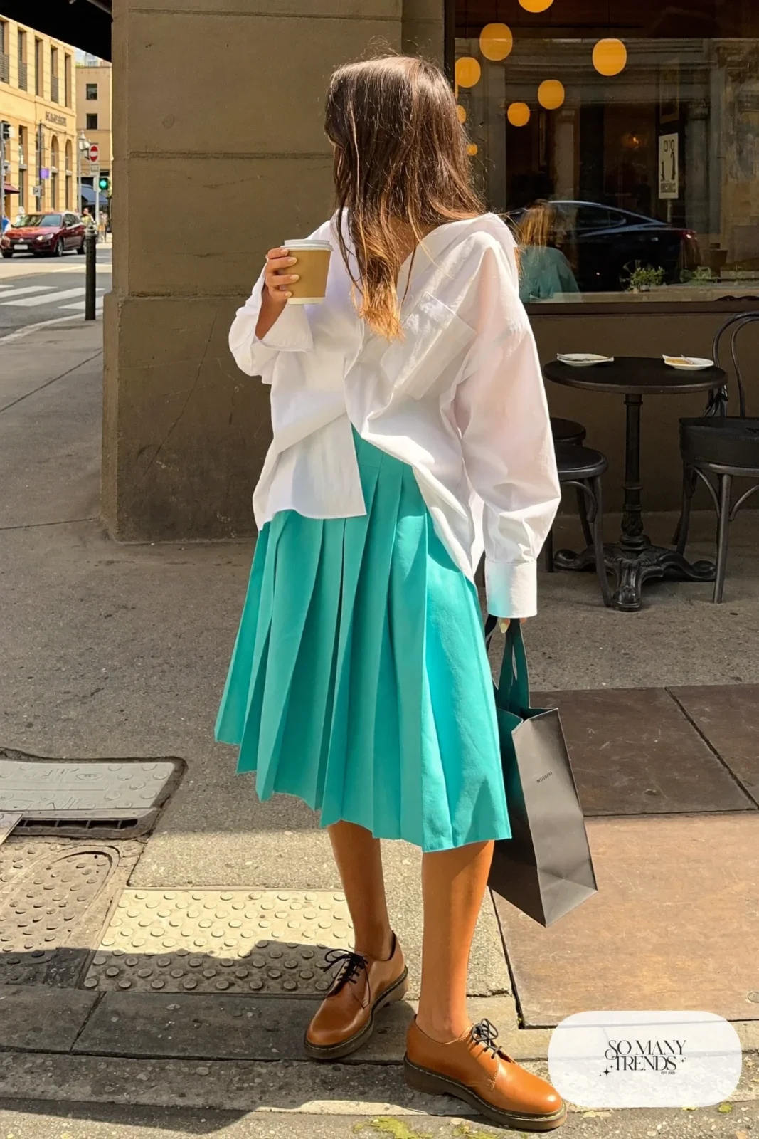 Woman in a turquoise pleated midi skirt, white shirt and tan oxford shoes, outfit 11