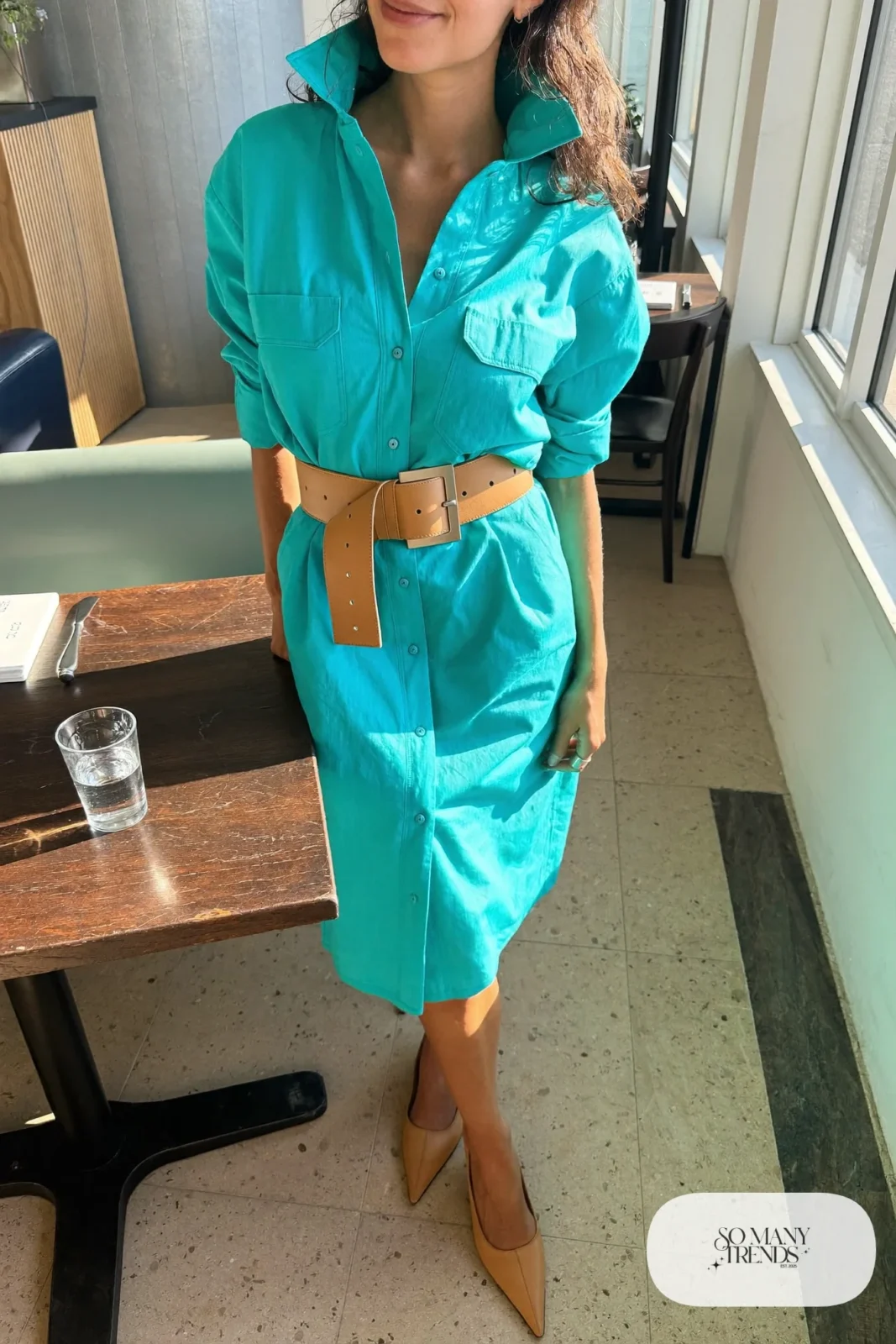 Woman in a turquoise shirt dress with a tan belt and tan pointed flats, outfit 14
