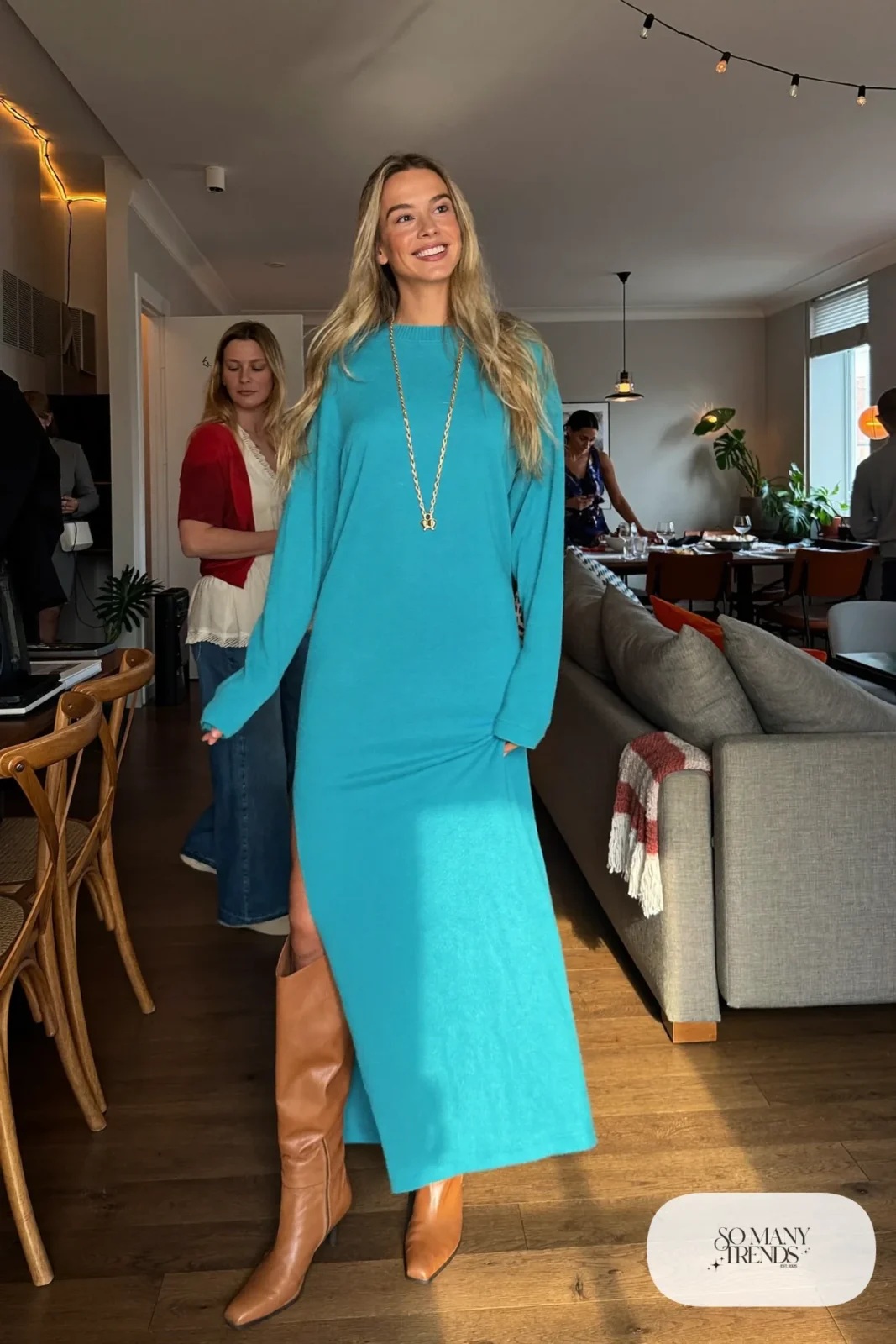 Woman in a turquoise knit maxi dress, tan tall boots and a gold chain, outfit 15