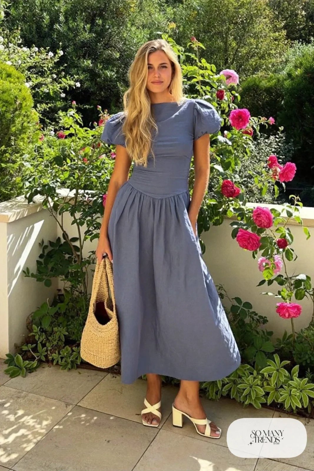 Woman in a slate blue cotton poplin midi dress with puff sleeves and cream block-heel sandals, garden party outfit 1
