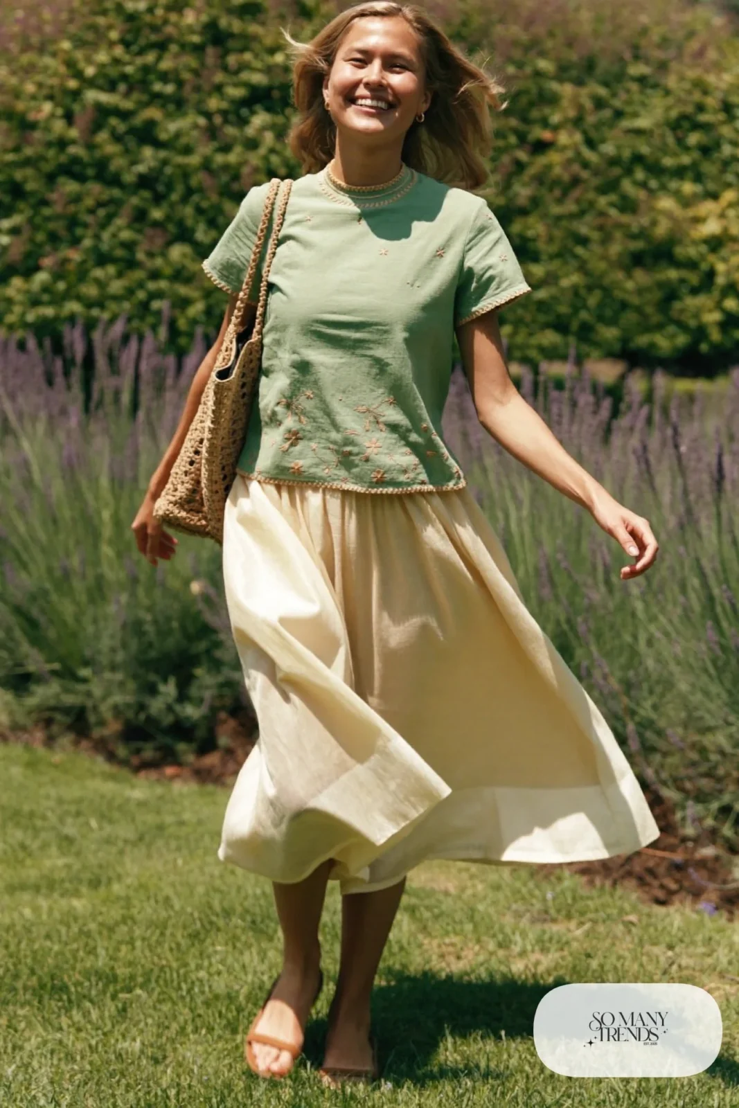 Woman in a mint embroidered cotton top and cream flowing midi skirt with flat sandals, garden party outfit 17