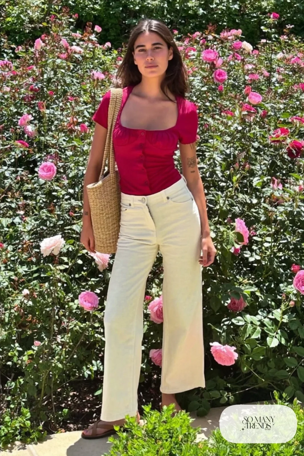 Woman in a wine cotton top and cream wide-leg pants with flat sandals and a woven bag, garden party outfit 24