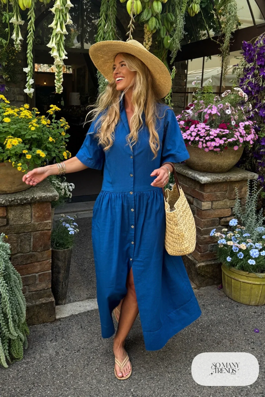 Woman in a cobalt blue cotton maxi dress with a wide-brim straw hat and flat woven sandals, garden party outfit 28