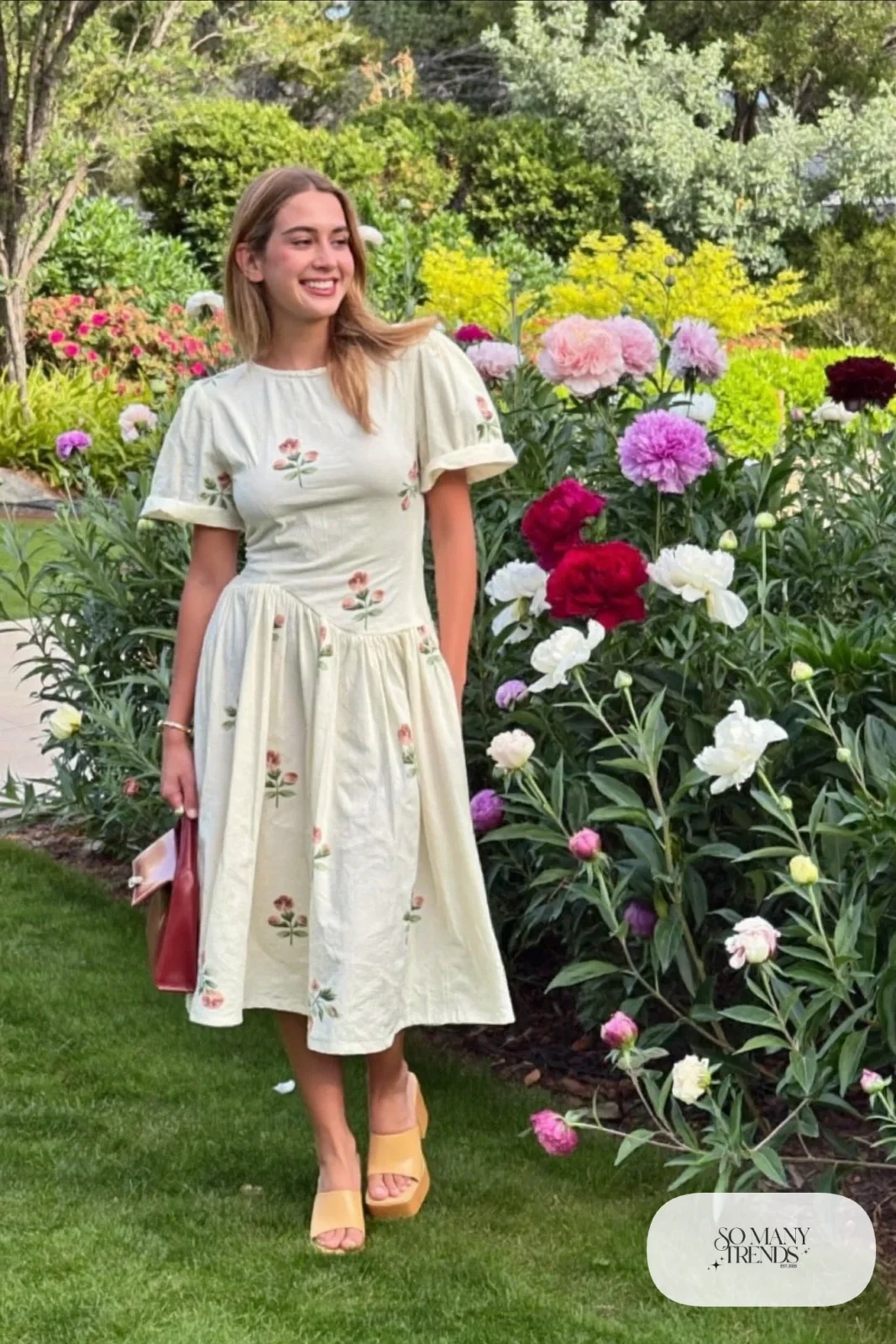 Woman in a cream embroidered cotton midi dress with a wine bag and tan block-heel sandals, garden party outfit 10