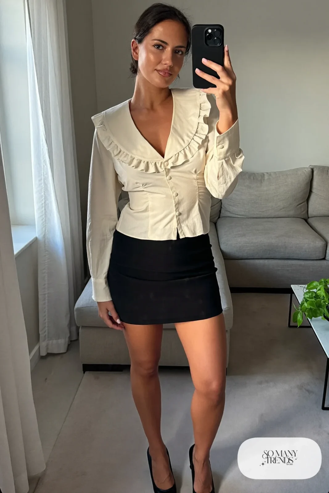 Look 16: ivory ruffle-collar blouse, black mini skirt, black heels, small ring, mirror selfie in the living room