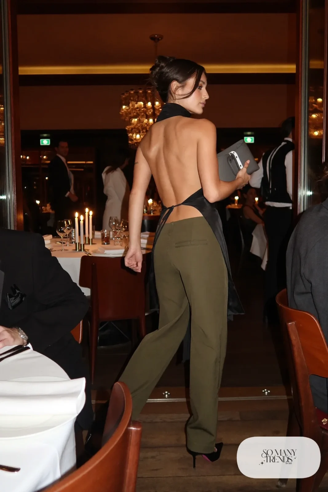 Look 19: black open-back halter top, olive wide-leg pants, black pointed heels, small clutch