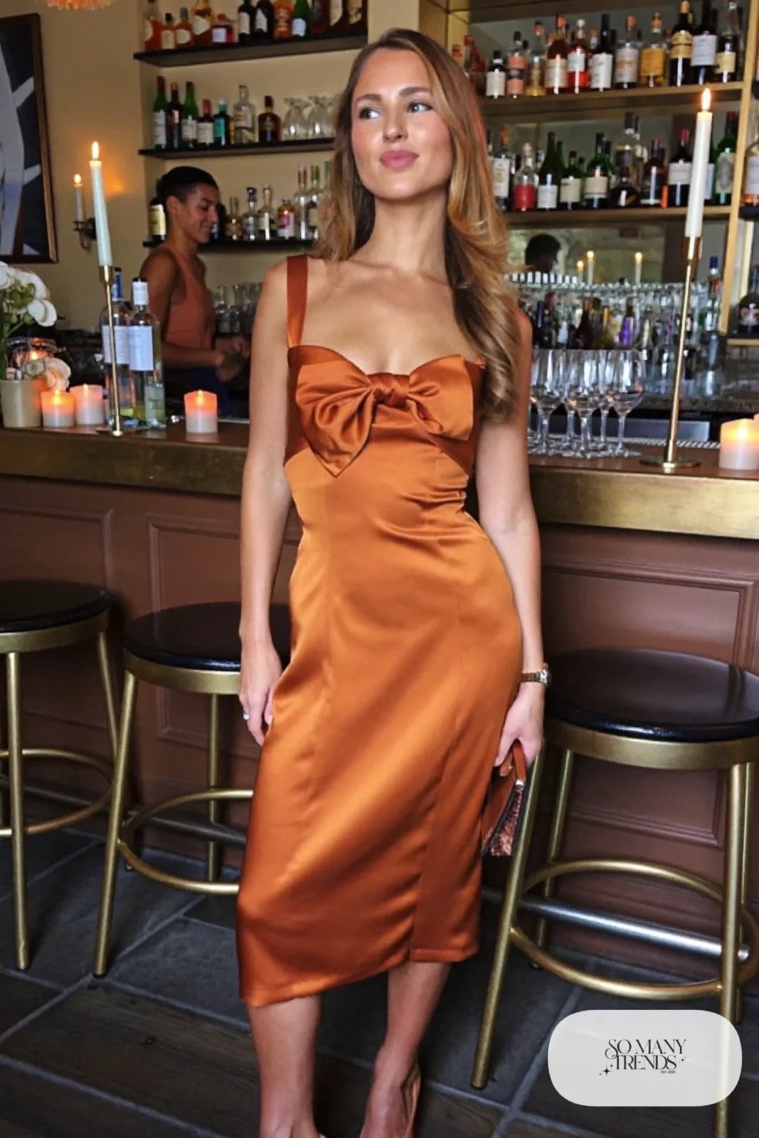 Look 30: caramel satin midi dress with a bow detail, tan heels, small clutch