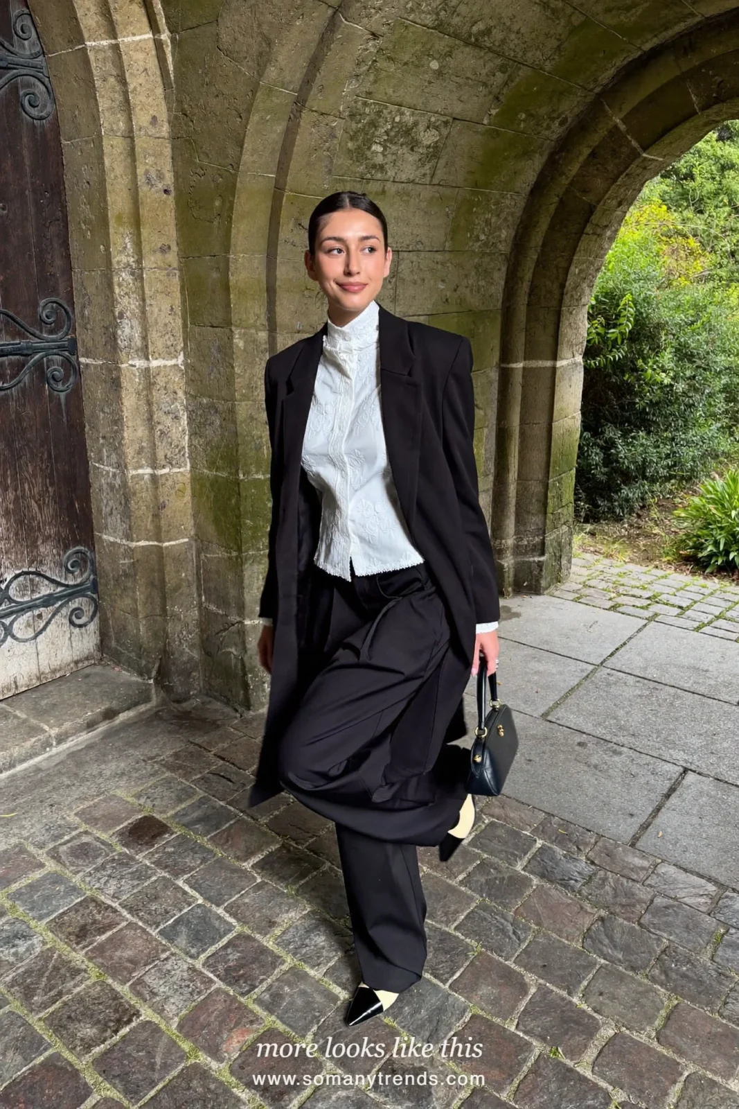 Woman in a black tuxedo blazer, white lace-collar blouse, black wide-leg pants and two-tone pumps, church outfit 3