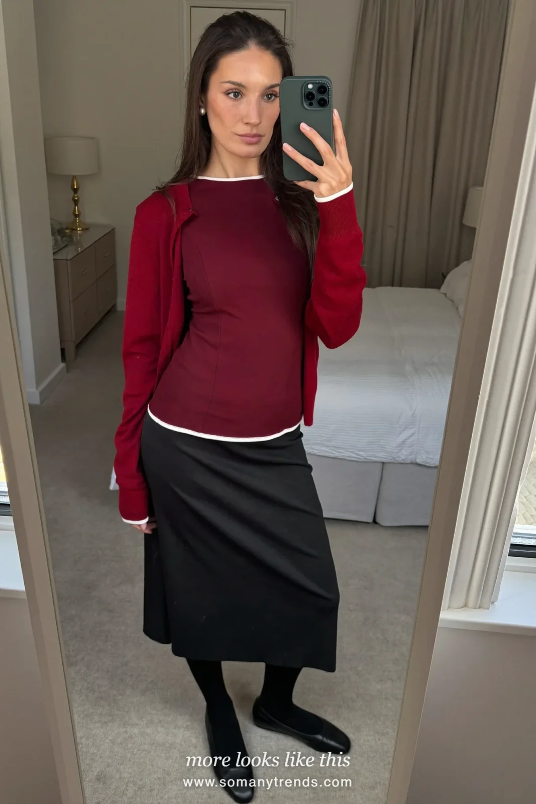 Woman in a burgundy cardigan and shell set, black skirt and pearl studs, church outfit 12