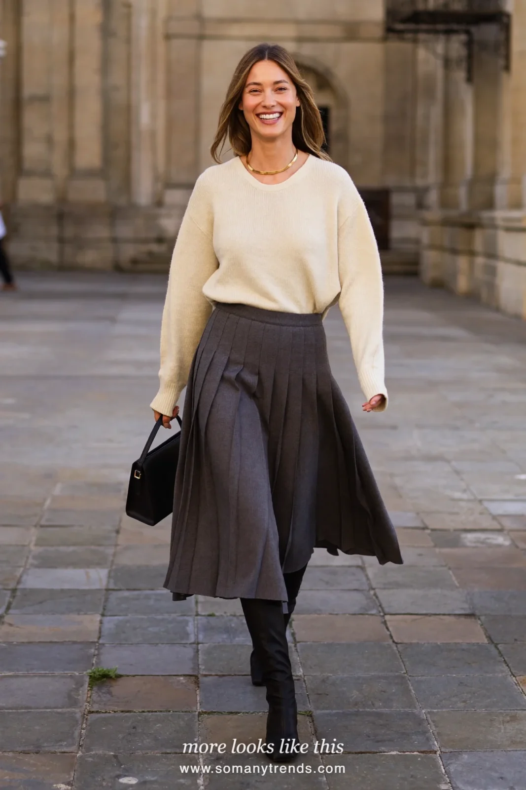 Woman in a charcoal pleated midi skirt, cream knit sweater and tall black boots, church outfit 19