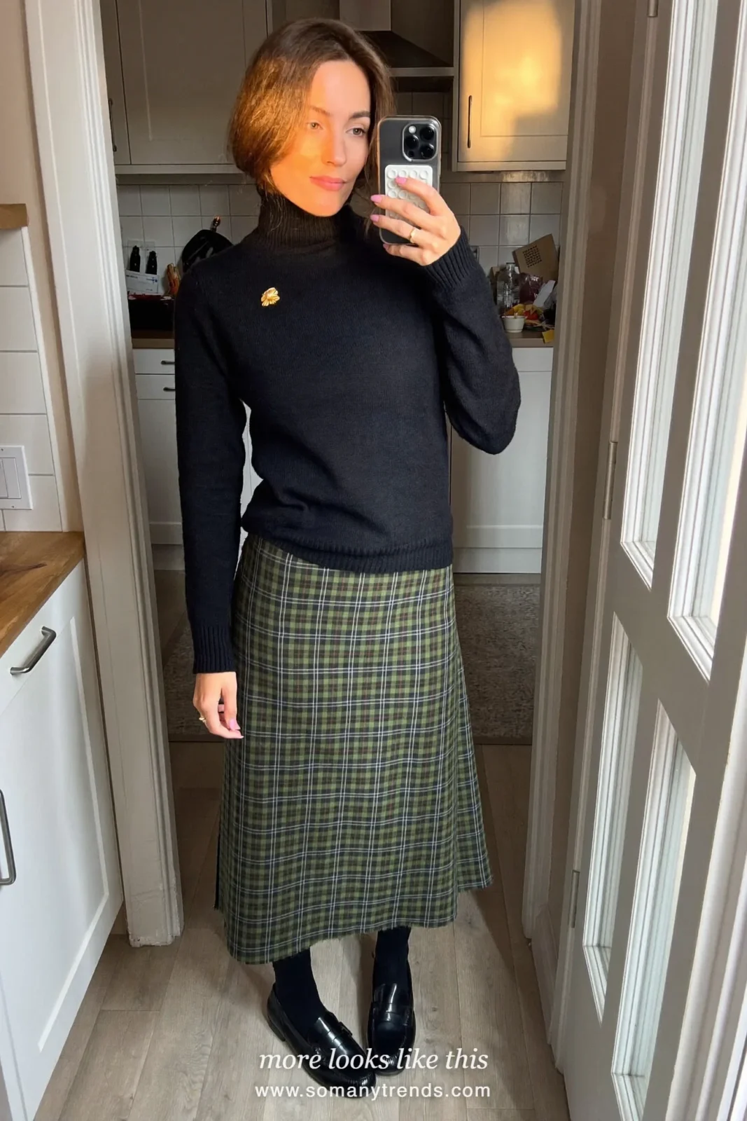 Woman in a black turtleneck, green plaid midi skirt, brooch and loafers, church outfit 24