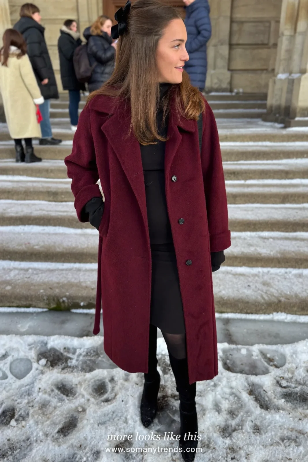 Woman in a burgundy long coat, black dress, velvet bow clip and black boots, church outfit 31