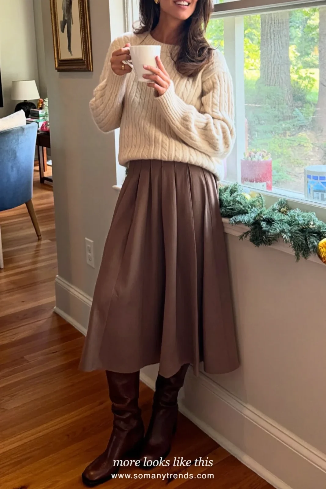 Cream cable knit sweater with a long chocolate pleated skirt and tall brown boots, Christmas outfit 6